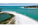 Breathtaking aerial view of a pristine white sand beach and turquoise ocean waters at 765 Saint Judes N Dr, Longboat Key, FL 34228