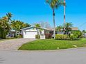 Charming single-story home with a well-manicured lawn, lush landscaping, and a paved driveway at 5303 Coral Blvd, Bradenton, FL 34210