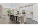 Modern kitchen features an island with seating, white cabinets, granite countertops, and stainless steel appliances at 12029 Perennial Pl, Lakewood Ranch, FL 34211