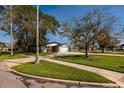 Charming single-story home with an attached garage, spacious driveway, lush lawn, and mature trees at 5500 Bayou Grande Ne Blvd, St Petersburg, FL 33703