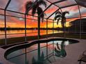 Enclosed pool area offers stunning sunset views over the lake, creating a tranquil and picturesque setting at 6920 74Th Street E Cir, Bradenton, FL 34203