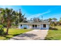 Lovely exterior view of a light blue home with a spacious front yard and a gravel driveway at 712 N Elm St, Englewood, FL 34223