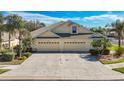 Inviting home featuring a double garage, brick driveway, and well-maintained landscaping at 9367 Hawk Nest Ln, North Port, FL 34287