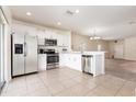 Bright kitchen with stainless steel appliances, white cabinets, tile flooring, and open layout to the dining area at 2347 Richwood Pike Dr, Ruskin, FL 33570