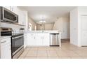 Updated kitchen with stainless steel appliances, white cabinets, granite counters, and tile flooring at 2347 Richwood Pike Dr, Ruskin, FL 33570