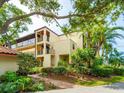 Inviting condo complex featuring balconies and lush tropical landscaping at 6430 Sun Eagle Ln # 201, Bradenton, FL 34210
