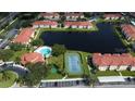 Aerial view of condo community featuring swimming pool, tennis court, and lake at 2950 Viscaya Pl # 205, Sarasota, FL 34237