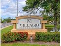 Villagio Condominium community sign with colorful flowers and greenery at 2950 Viscaya Pl # 205, Sarasota, FL 34237