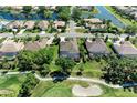 An aerial view of the home with a golf course and a lake nearby in a neighborhood at 5304 96Th E St, Bradenton, FL 34211