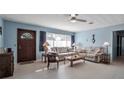 Bright living room with a large window, ceiling fan, and traditional furnishings at 5808 13Th Street E Ct, Bradenton, FL 34203
