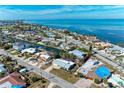 Waterfront homes line a canal leading to the bay, landscaped with lush palms and tropical greenery at 609 Foxworth Ln, Holmes Beach, FL 34217