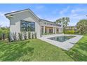 Beautiful backyard featuring a pristine pool, lush green lawn, and elegant landscaping at 656 Tropical Cir, Sarasota, FL 34242