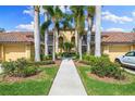 Beautiful home exterior with palm trees, lush landscaping, and a well-maintained walkway leading to the entrance at 7149 River Hammock Dr # 101, Bradenton, FL 34212