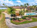 Scenic aerial view of the community pool, cabana, and landscaping near the property, situated by a pond at 7149 River Hammock Dr # 101, Bradenton, FL 34212