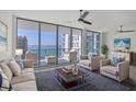 Bright living room boasts expansive windows offering stunning waterfront views, neutral furniture, and chic decor at 301 Quay Commons # 1411, Sarasota, FL 34236