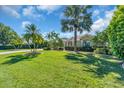 Well-manicured front yard with mature trees, green lawn, and lush landscaping at 3336 Lakeside Cir, Parrish, FL 34219