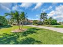 Beautifully landscaped front yard with mature palms and a paver driveway at 3336 Lakeside Cir, Parrish, FL 34219