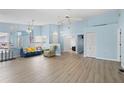 Spacious living room featuring light wood flooring, ample natural light, and a modern ceiling fan at 5388 Pamela Wood Way # 8, Sarasota, FL 34233