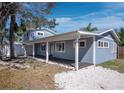 Charming coastal home featuring a covered porch, durable siding, well-placed windows, and lovely landscaping at 651 Fox St, Longboat Key, FL 34228