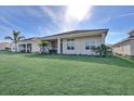 Expansive backyard with lush lawn, tropical plants, and covered patio at 17915 Palmiste Dr, Bradenton, FL 34202