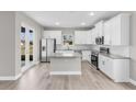 Bright kitchen featuring white cabinetry, stainless steel appliances, granite countertops and island at 514 Santiguay St, Punta Gorda, FL 33983