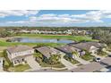 Exterior shot of homes overlooking a golf course with water features, surrounded by mature trees and landscaping at 7812 Birdie Bend Way, Sarasota, FL 34241