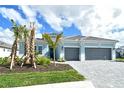Beautiful single-Gathering home showcasing a manicured front yard with palm trees and a convenient two-car garage at 12440 Meribel St, Venice, FL 34293