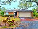 Charming brick home boasts a two-car garage, mailbox, landscaped pathway, and covered front entry at 1407 Willow Oak Cir, Bradenton, FL 34209