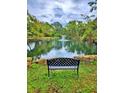 Scenic pond view with a fountain, surrounded by lush trees, and a bench in the foreground at 1407 Willow Oak Cir, Bradenton, FL 34209