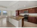 Open kitchen with granite countertops, stainless steel appliances, and an island sink at 16904 Vardon Ter # 102, Bradenton, FL 34211