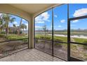 Screened lanai featuring brick flooring with a view of the community lake and lush landscaping at 16904 Vardon Ter # 102, Bradenton, FL 34211
