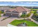 An aerial showcases the home's double garage, manicured lawn, and paver driveway, enhancing its curb appeal at 3105 Formia Ct, Bradenton, FL 34211