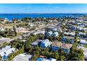 Aerial view of blue coastal home surrounded by mature landscaping, near the ocean and town at 312 61St St # A, Holmes Beach, FL 34217