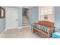 Light and airy entryway features tile flooring, stairs, and a wicker bench at 312 61St St # A, Holmes Beach, FL 34217