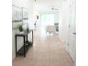 Inviting hallway with tile floors, console table, and artwork leading to the living area at 5718 Broad River Run, Ellenton, FL 34222