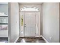 Bright entryway featuring a white front door with sidelights and transom window at 8570 Tropicaire Blvd, North Port, FL 34291