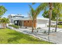 Modern home with sleek design, showcasing a meticulously landscaped front yard and contemporary architectural features at 2149 Hyde Park St, Sarasota, FL 34239