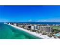 Beautiful aerial shot of beachfront condos, clear turquoise waters, and manicured landscapes at 435 L Ambiance Dr # L807, Longboat Key, FL 34228