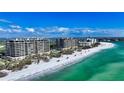 Stunning aerial view of beachfront condos with pristine white sand and turquoise waters at 435 L Ambiance Dr # L807, Longboat Key, FL 34228