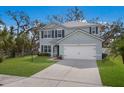 Inviting two-story home with a well-maintained lawn, a two-car garage, and a classic architectural design at 5809 71St E St, Palmetto, FL 34221