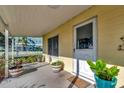 A home's covered front porch features a white door, large window and potted plants at 1206 2Nd E Ave, Bradenton, FL 34208