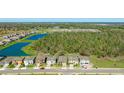An aerial view shows a home near a lake and surrounded by green spaces in a vibrant community at 12750 Oak Hill Way, Parrish, FL 34219