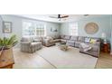 Comfortable living room with a large sectional sofa, light wood floors, and bright, coastal decor at 2211 Avenue C, Bradenton Beach, FL 34217