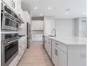 Close up on a kitchen featuring stainless appliances and a large center island with a sink at 26908 Victoria Pl, Punta Gorda, FL 33955