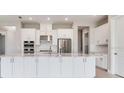 Modern kitchen with an oversized island, stainless steel appliances, and bright white cabinets at 26908 Victoria Pl, Punta Gorda, FL 33955