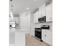 Well-equipped kitchen with stainless steel appliances, white cabinets, quartz countertops, and modern fixtures at 26930 Lark Ct, Punta Gorda, FL 33955