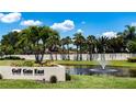 Picturesque Gulf Gate East community sign in a lush setting with water feature and mature palm trees at 3739 Kingston Blvd, Sarasota, FL 34238