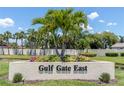 Manicured entrance to Gulf Gate East featuring lush landscaping and mature palm trees at 3739 Kingston Blvd, Sarasota, FL 34238