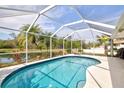 Relaxing screened-in pool with a sunny patio overlooking a lush private backyard and tranquil pond at 406 116Th E St, Bradenton, FL 34212