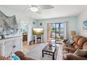 Cozy living room with a ceiling fan, comfortable seating, and a sliding glass door to a balcony with a view at 460 S Paula Dr # 304, Dunedin, FL 34698